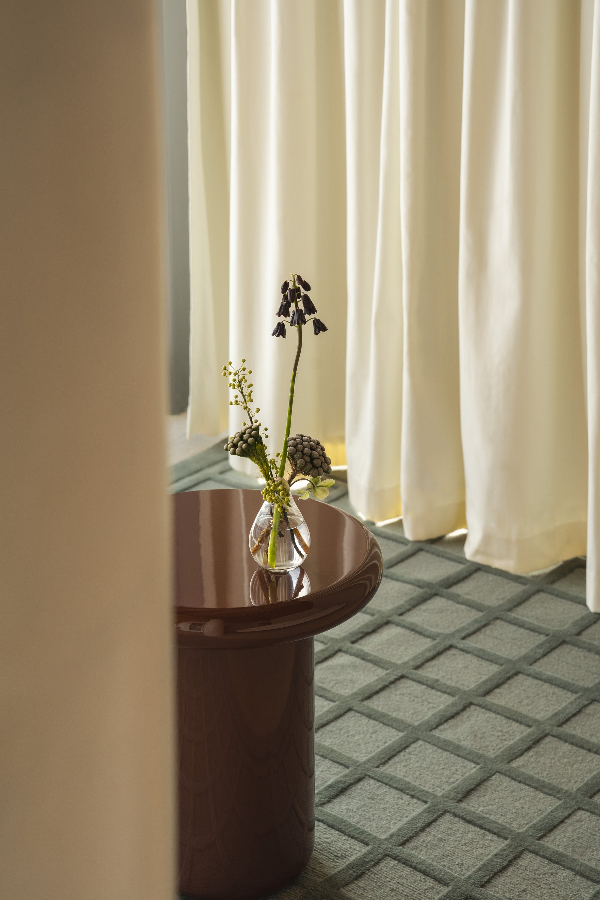 Mieux Mile side table in merlot gloss displayed on modern blue rug